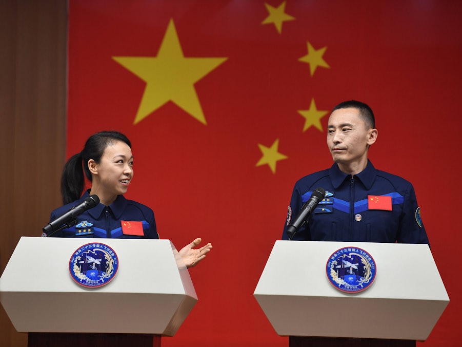 Astronauten Li Jiaying & Zhu Yangzhu sprechen vor Flagge