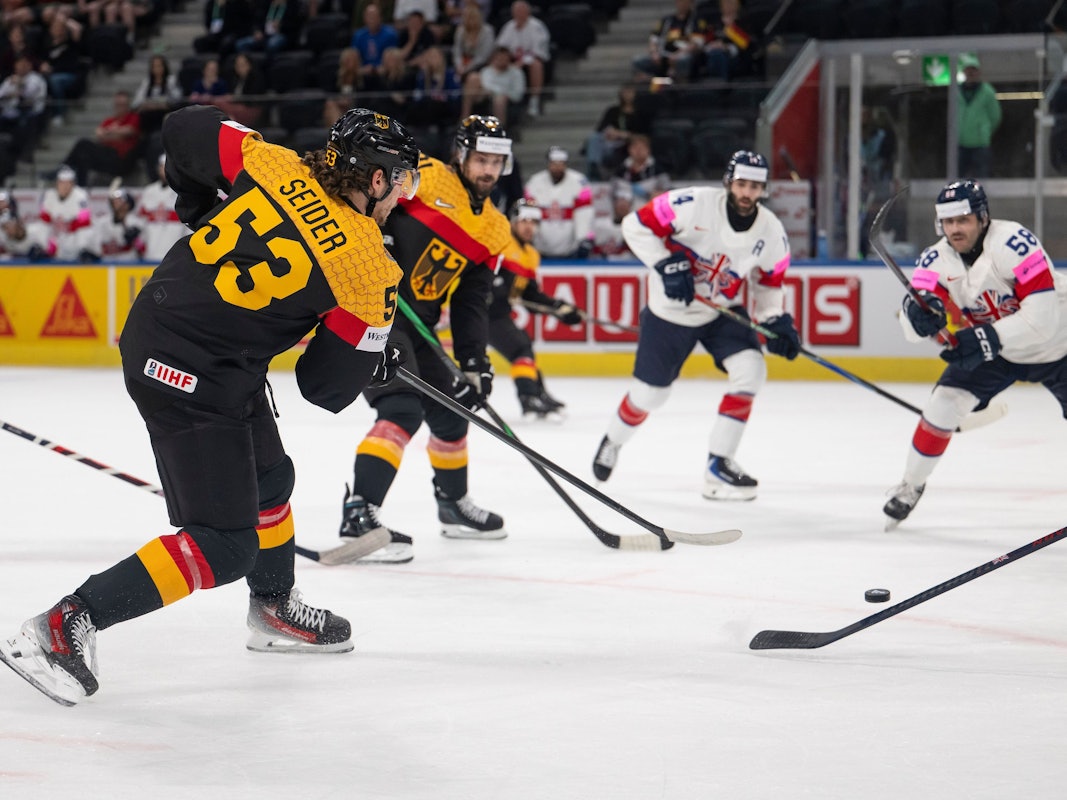 Deutschlands Moritz Seider (l.) schießt den Puck.