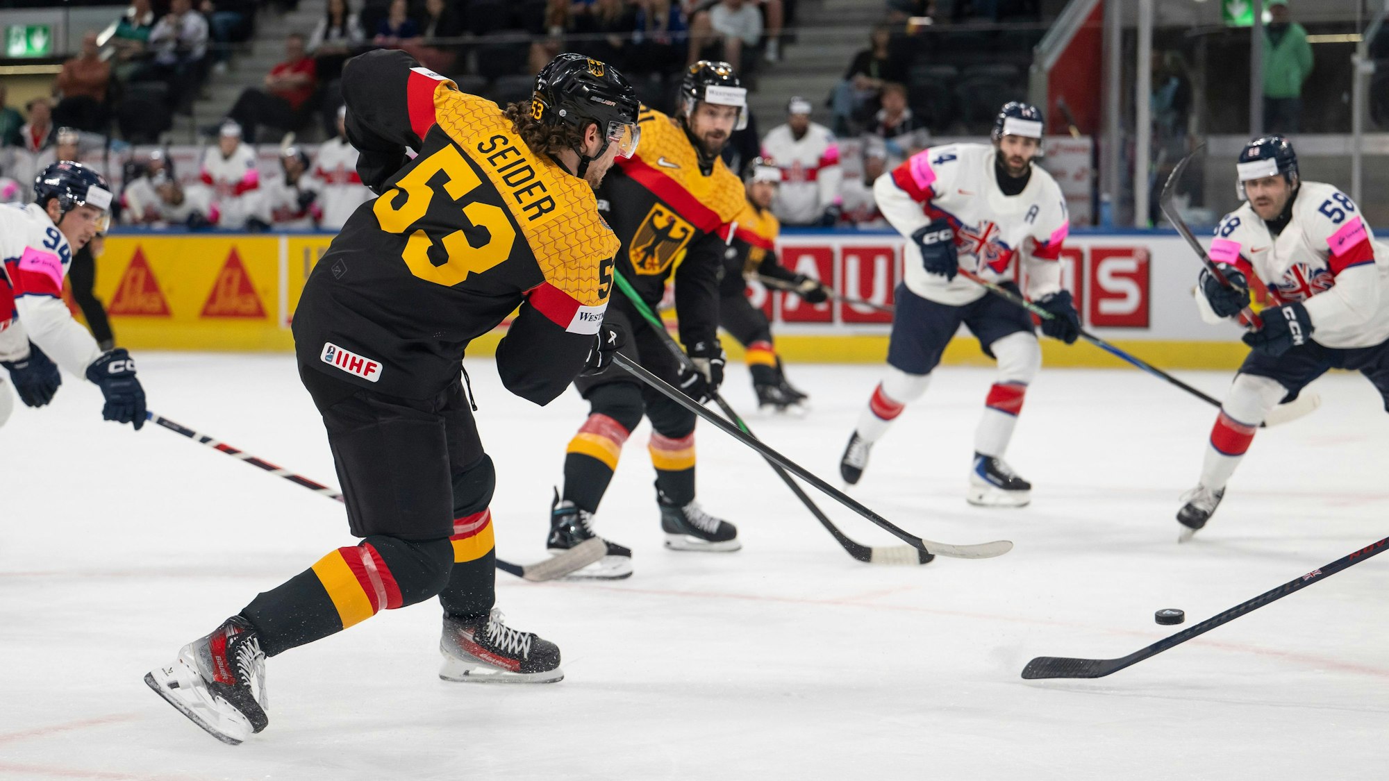 Deutschlands Moritz Seider (l.) schießt den Puck.