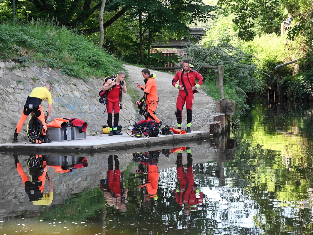 Taucher machen sich an einem Flussufer bereit.