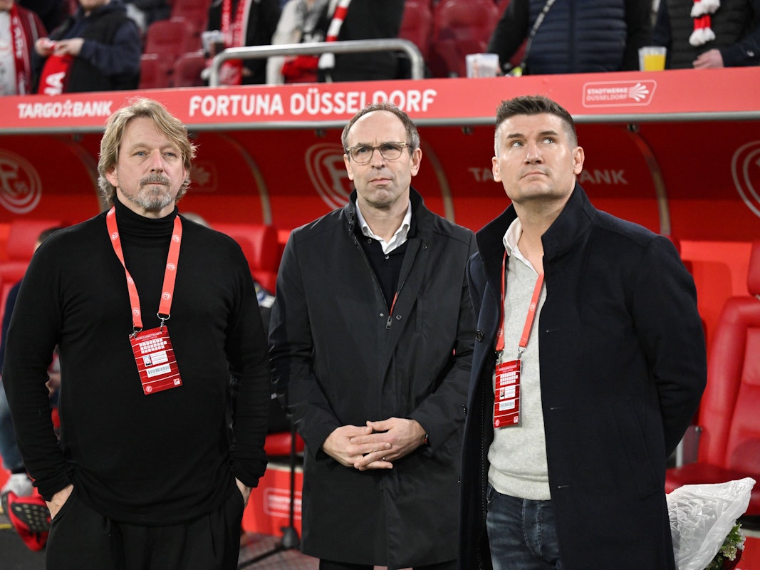 V.l.: Sven Mislintat, Alexander Jobst und Arnd Hovemann stehen vor der Auswechselbank von Fortuna Düsseldorf.