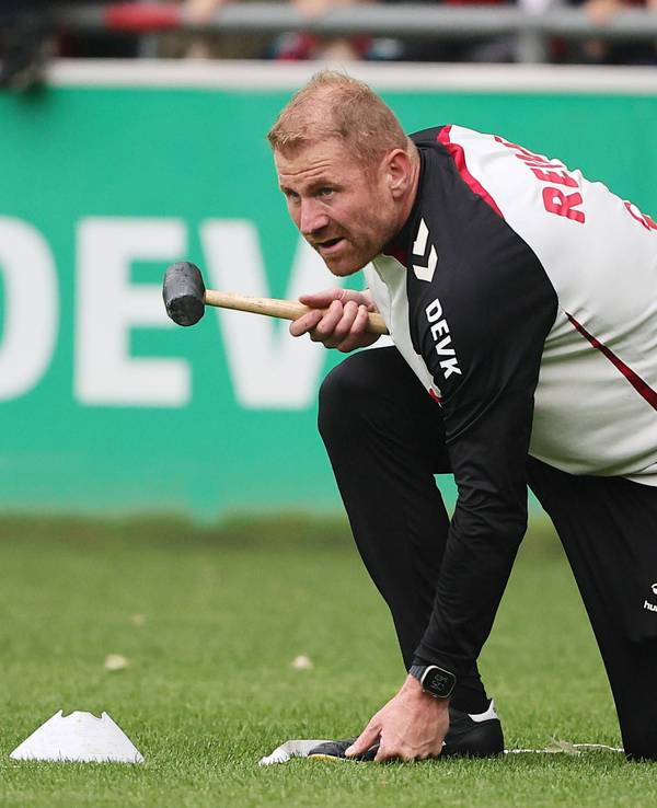 Lukas Sinkiewicz hält auf dem Platz einen Hammer in der Hand.