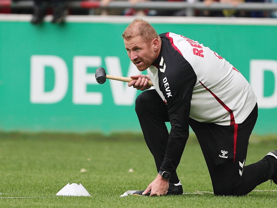 Lukas Sinkiewicz hält auf dem Platz einen Hammer in der Hand.