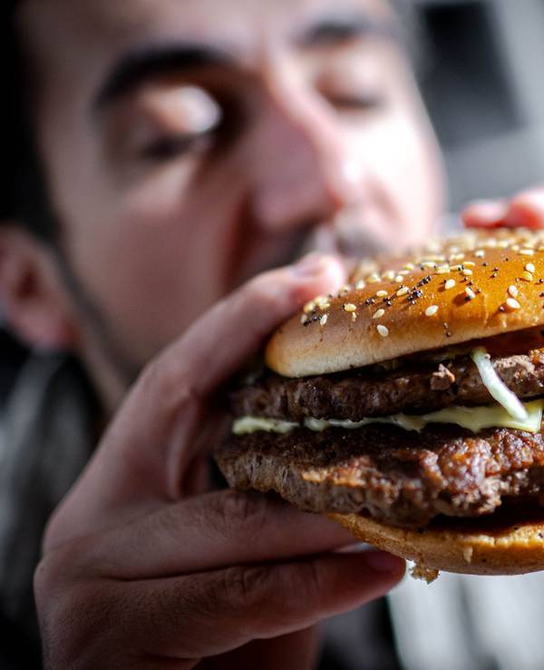 Mann beißt in einen Burger