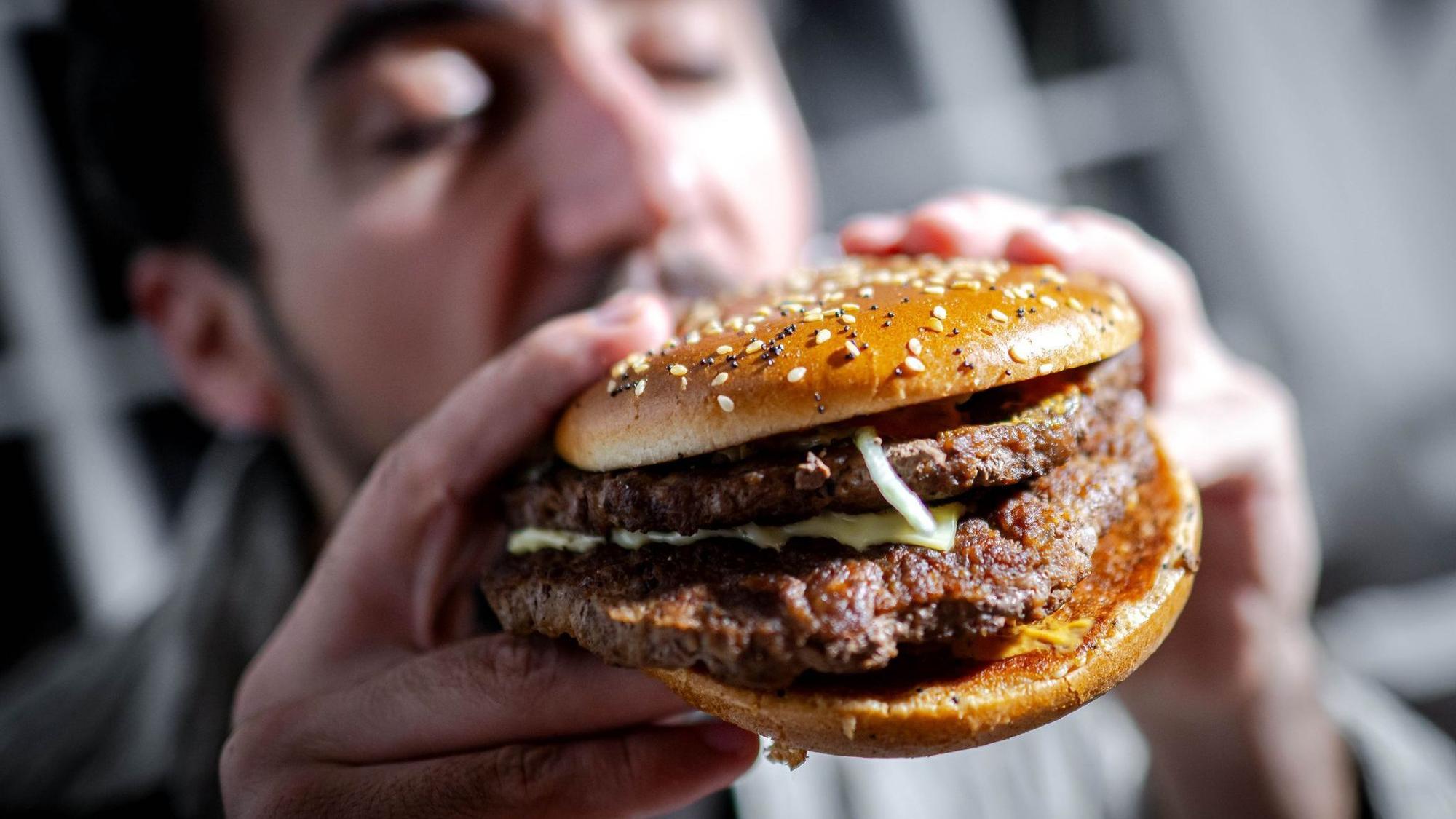 Mann beißt in einen Burger