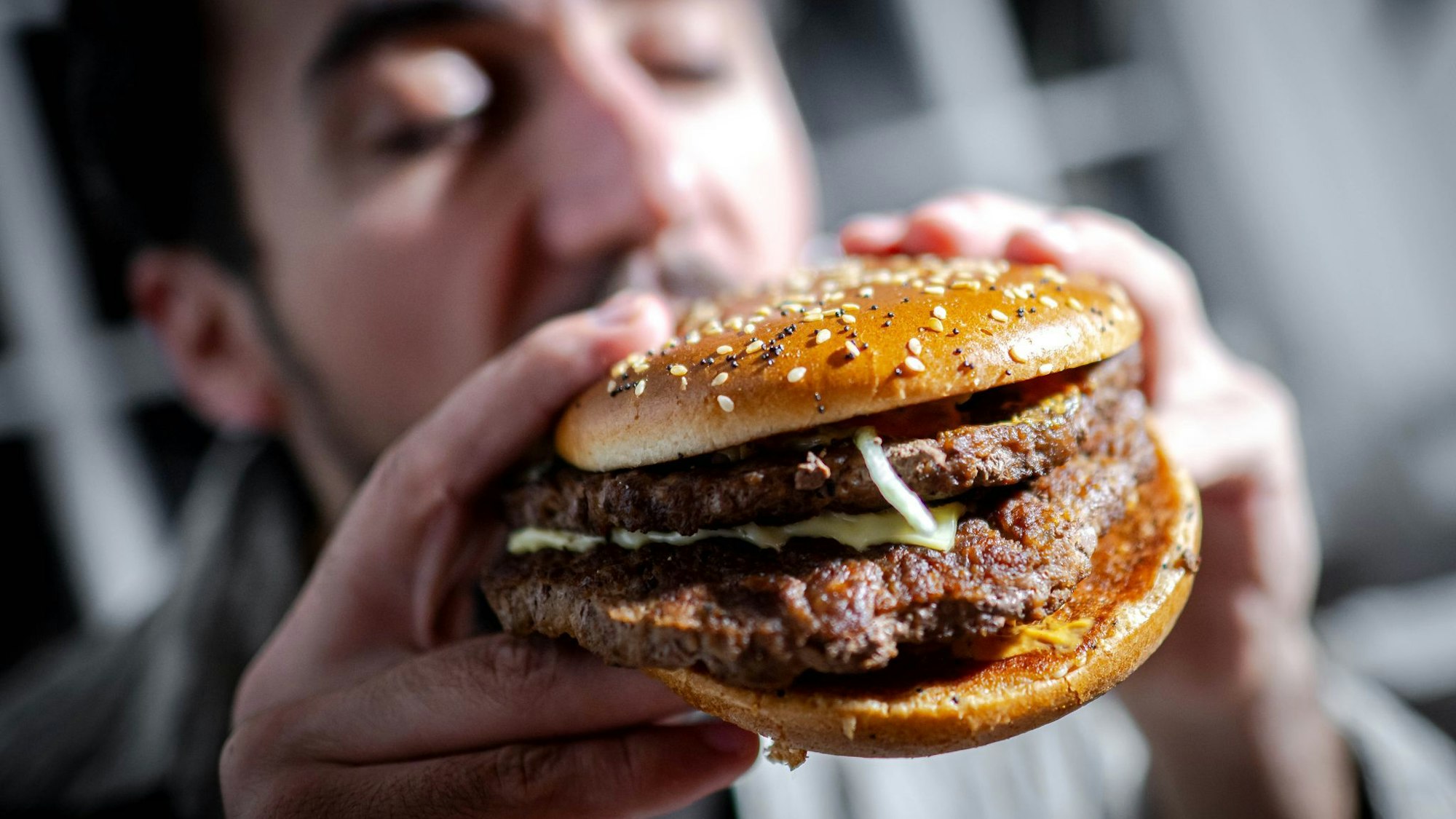 Mann beißt in einen Burger
