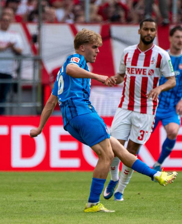 Hennes Behrens spielt einen Pass, Linton Maina schaut zu.