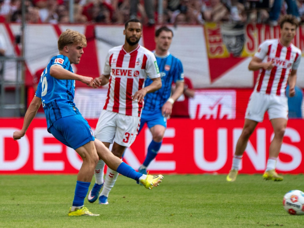 Hennes Behrens spielt einen Pass, Linton Maina schaut zu.