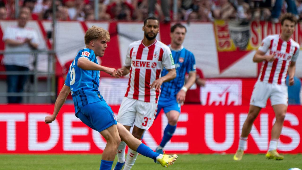 Hennes Behrens spielt einen Pass, Linton Maina schaut zu.