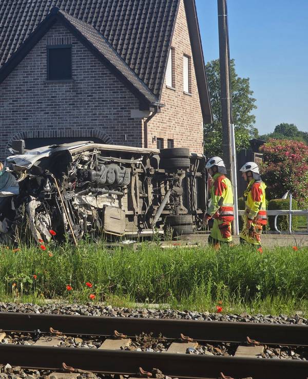 Rettungskräfte sind bei einem Unfallort im Einsatz, nachdem ein Zug mit einem Schulbus am Bahnübergang Vierhuizen in Buggenhout zusammengestoßen war.