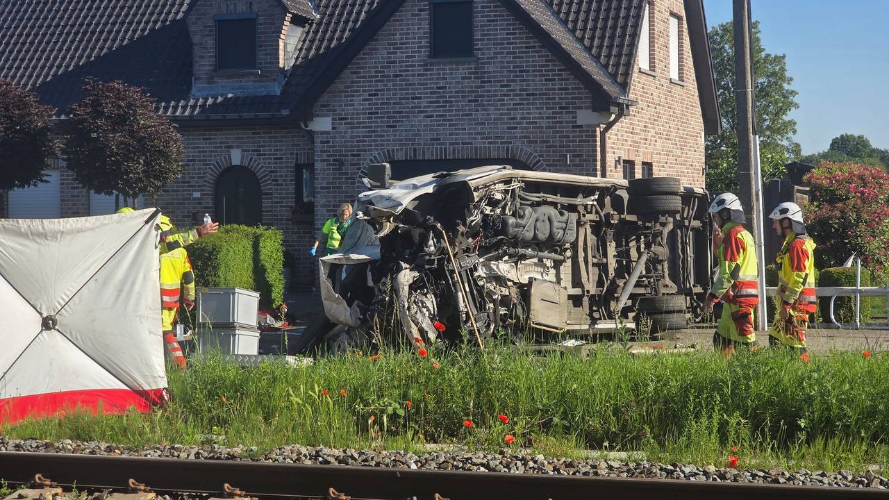 Rettungskräfte sind bei einem Unfallort im Einsatz, nachdem ein Zug mit einem Schulbus am Bahnübergang Vierhuizen in Buggenhout zusammengestoßen war.