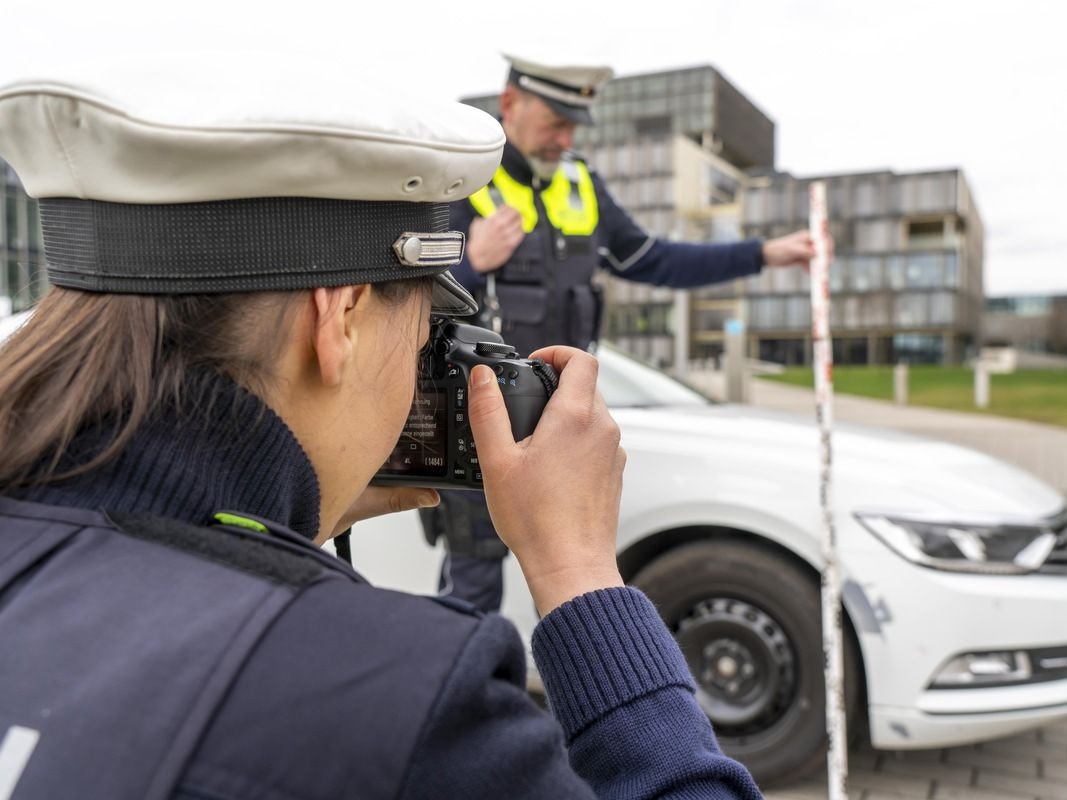 Ein Polizeiwagen mit Blaulicht steht auf einer Straße. (Symbolbild)