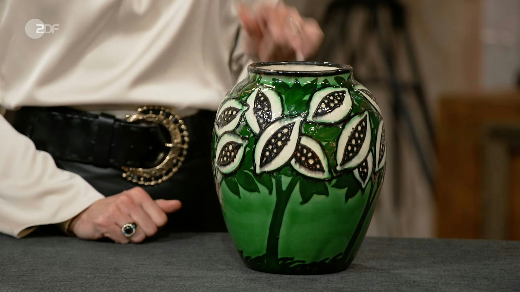 Seit vielen Jahren befand sich die Vase mit auffälligem Kakaobohnen-Dekor im Familienbesitz von Lena aus Hasbergen. „Jetzt hat meine Mutter mir die Keramik geschenkt“, erzählte die Verkäuferin. Und auch Bianca Berding war begeistert: „Das war ein super Geschenk“, denn die kunstvolle Bemalung erinnerte „ganz, ganz, ganz stark an Max Laeuger“. (Bild: ZDF)