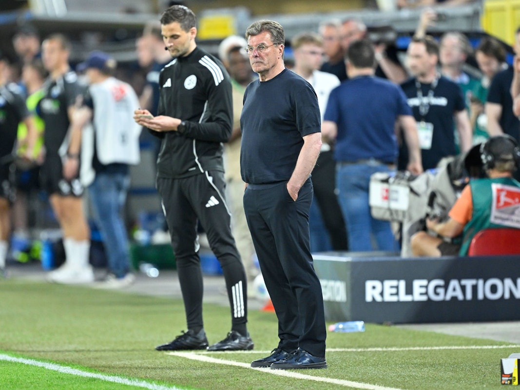 Trainer Dieter Hecking steht an der Seitenlinie mit beiden Händen in den Hosentaschen.