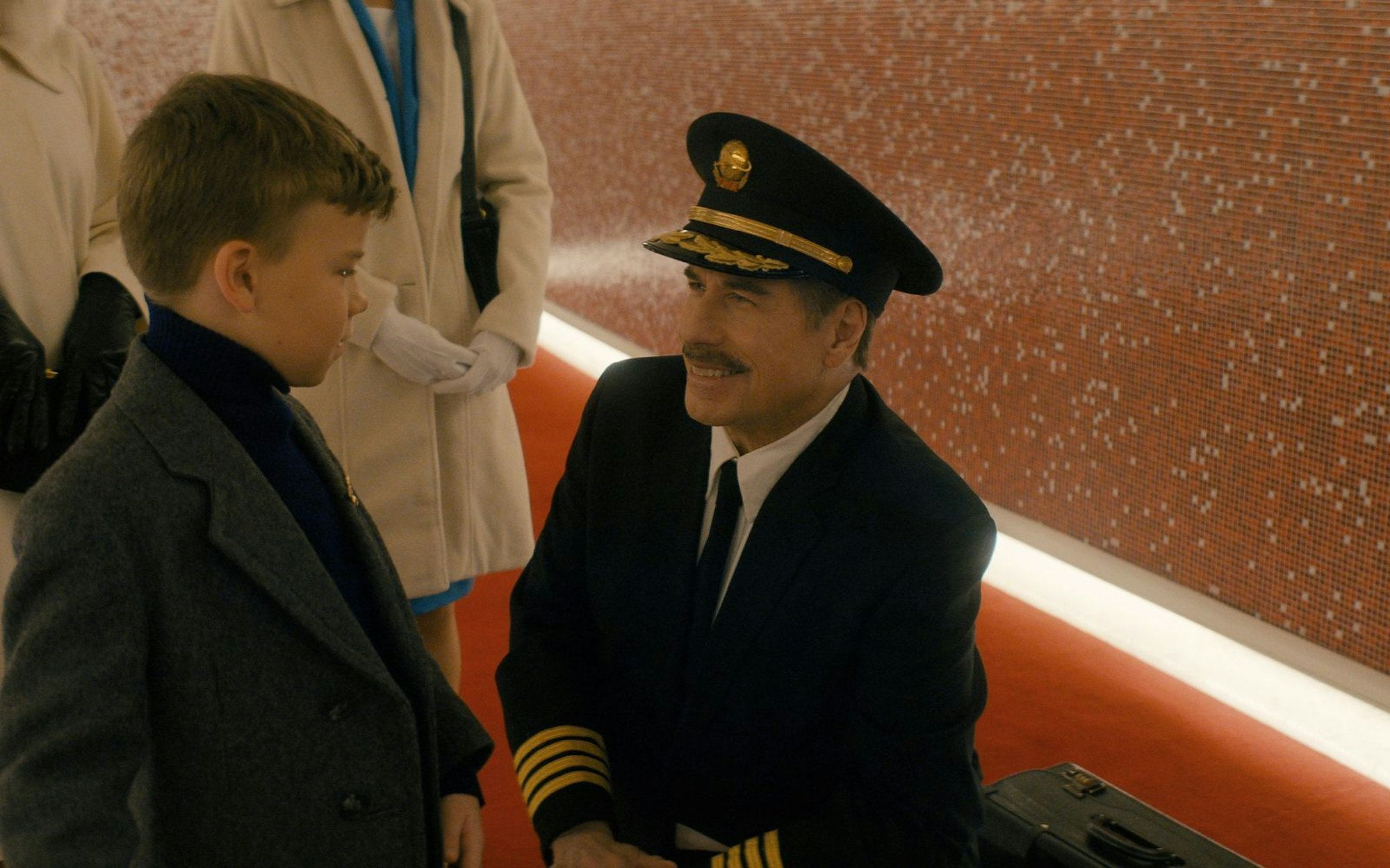 Der Pilot seines Jets von Denver nach Los Angeles (John Travolta, rechts) geht in Rente und wird am Flughafen dafür geehrt. So schafft es auch der achtjährige Jeff (Clark Shotwell) ins Rampenlicht von Los Angeles. Es gibt schlechtere Starts für ein Leben in Kalifornien. (Bild: Apple TV)