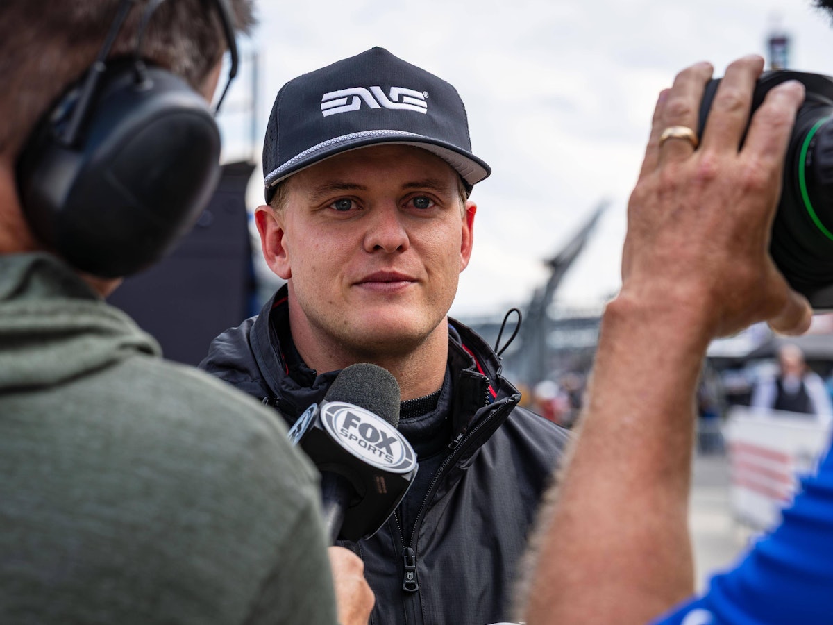 Mick Schumacher spricht bei einem Interview in ein Mikrofon.