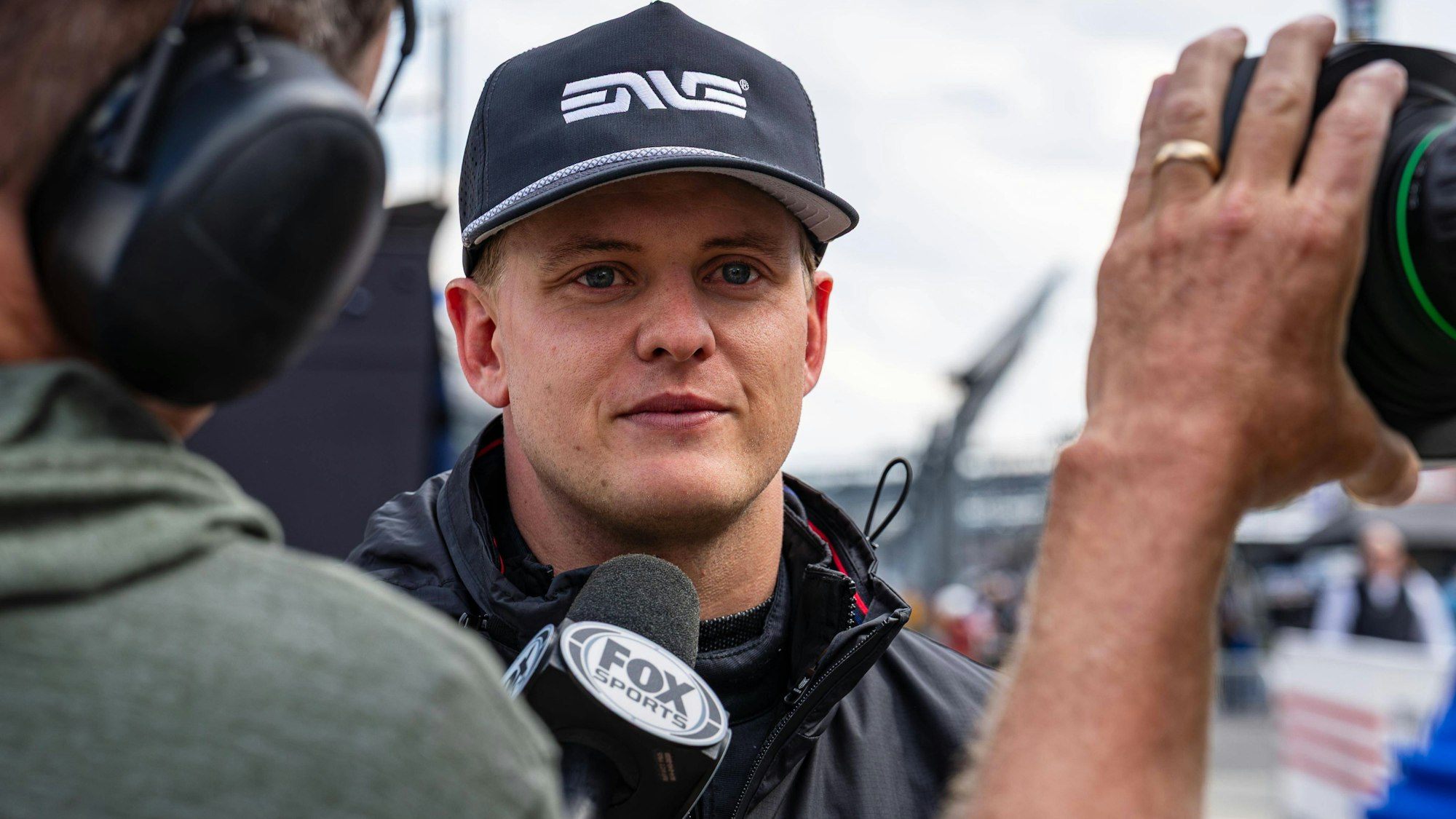 Mick Schumacher spricht bei einem Interview in ein Mikrofon.