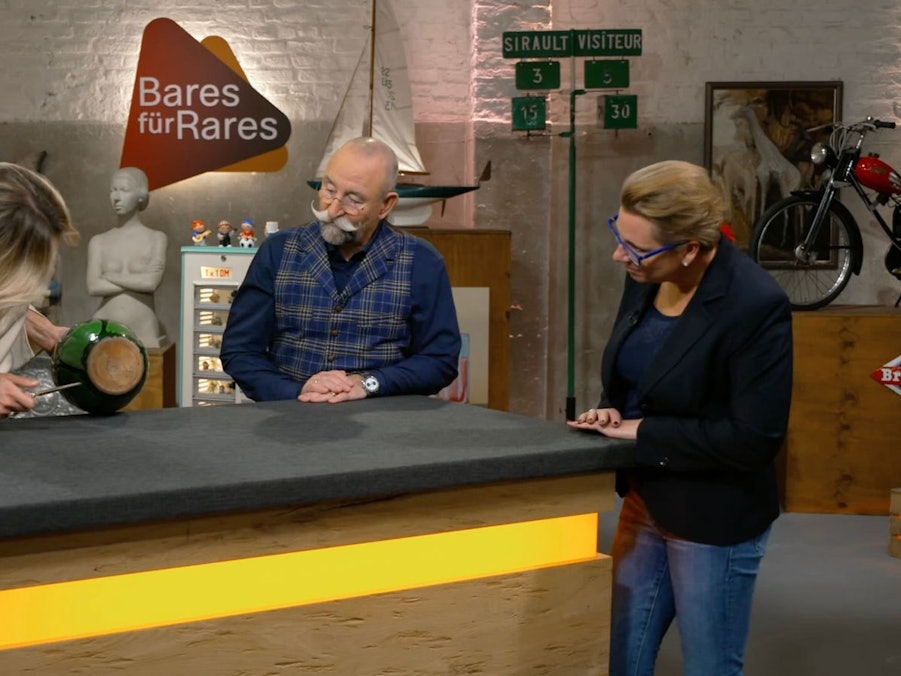 Verkäuferin Lena wurde in der Mittwochsausgabe der ZDF-Trödelshow „Bares für Rares“ bei Horst Lichter enttäuscht: „Leider nicht das, was ich hören wollte“, erwiderte sie nach der Expertise ihrer Jugendstil-Vase. Denn am Boden fehlte ein bestimmtes Künstlersignet. Einer Händlerin war das anscheinend nicht wichtig. Sie verdoppelte den Wunschpreis. (Bild: ZDF)