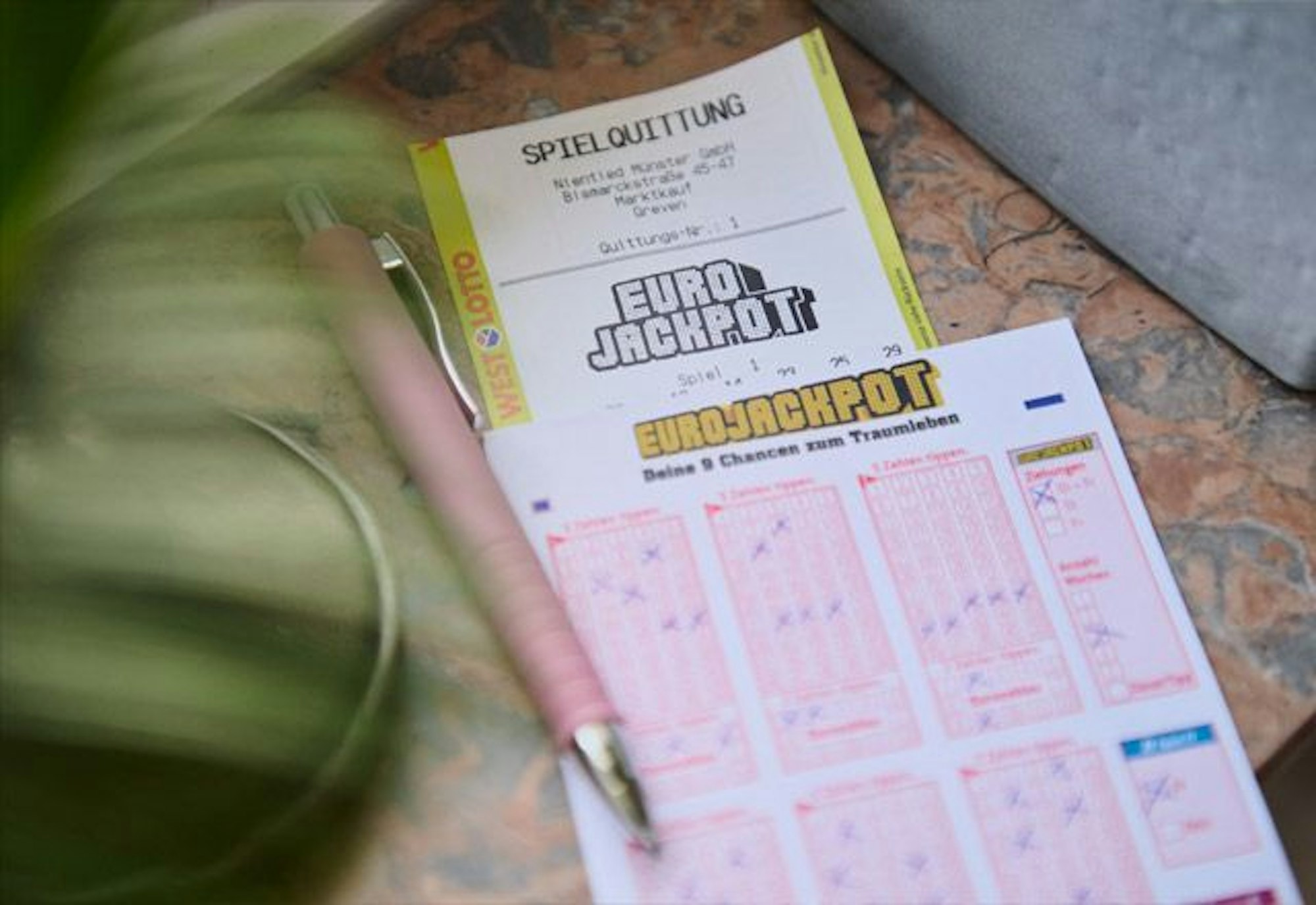 Das Bild zeigt einen Eurojackpot-Spielschein zusammen mit einer Eurojackpot-Spielquittung.