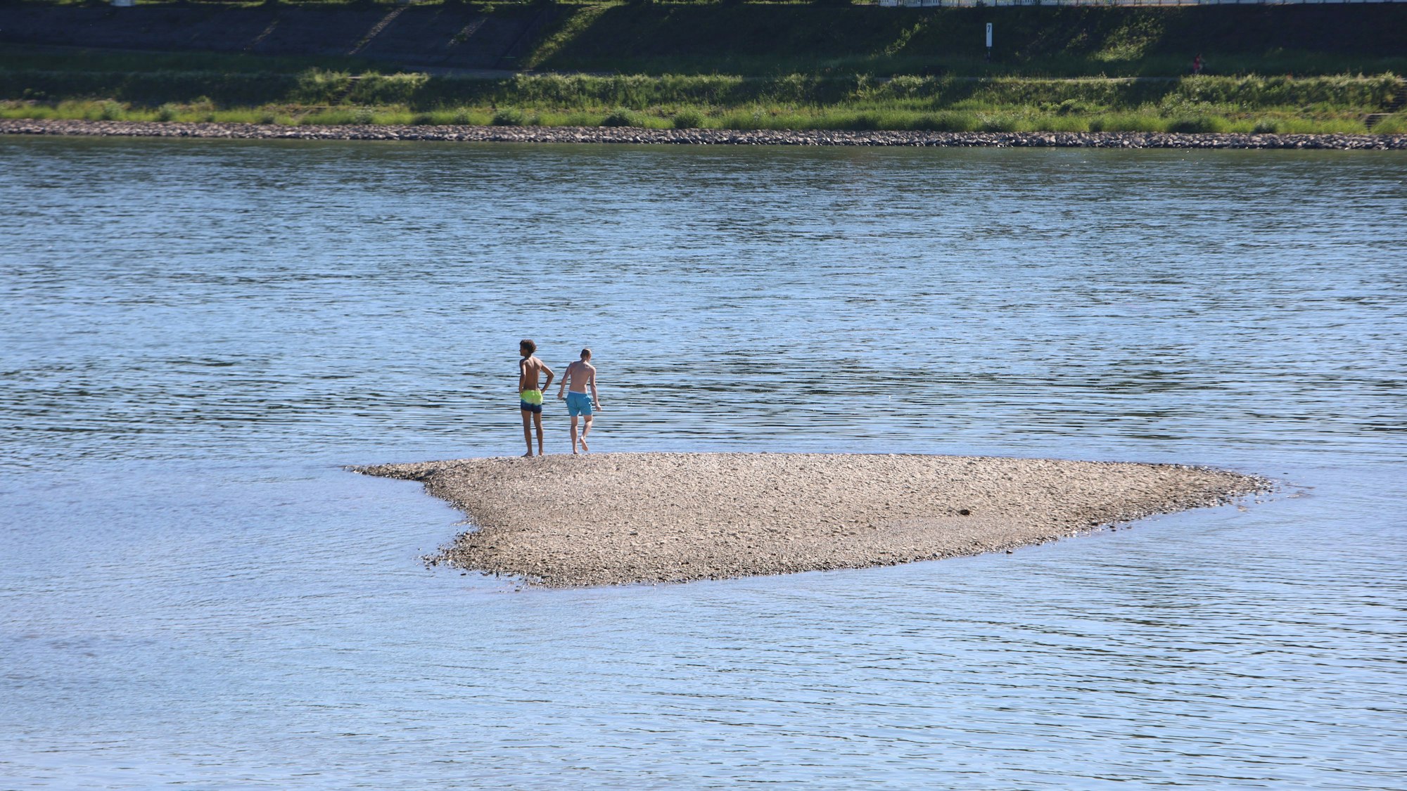 Das Baden und Schwimmen im Rhein ist seit dem letzten Jahr verboten. Einige Personen gehen trotzdem ins Wasser.