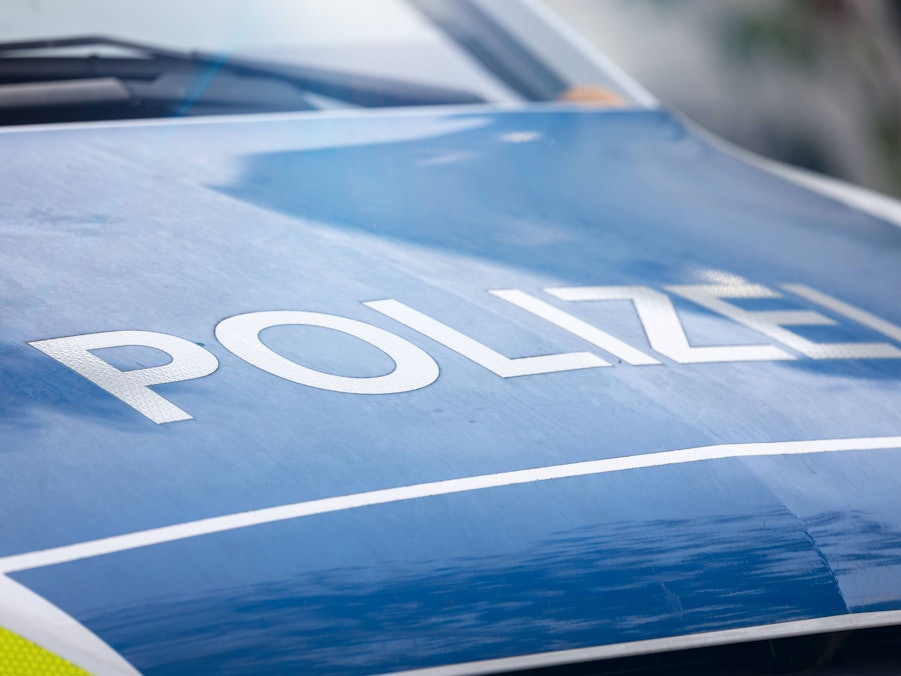Blaues Polizeifahrzeug mit Aufschrift