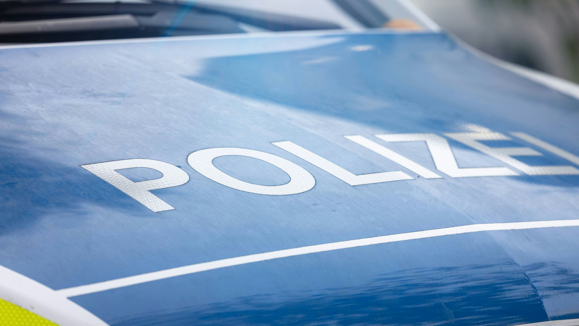 Blaues Polizeifahrzeug mit Aufschrift