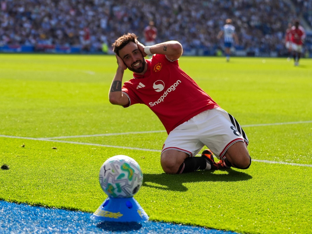 Bruno Fernandes kniet auf dem Rasen und fasst sich mit beiden Händen an den Kopf.