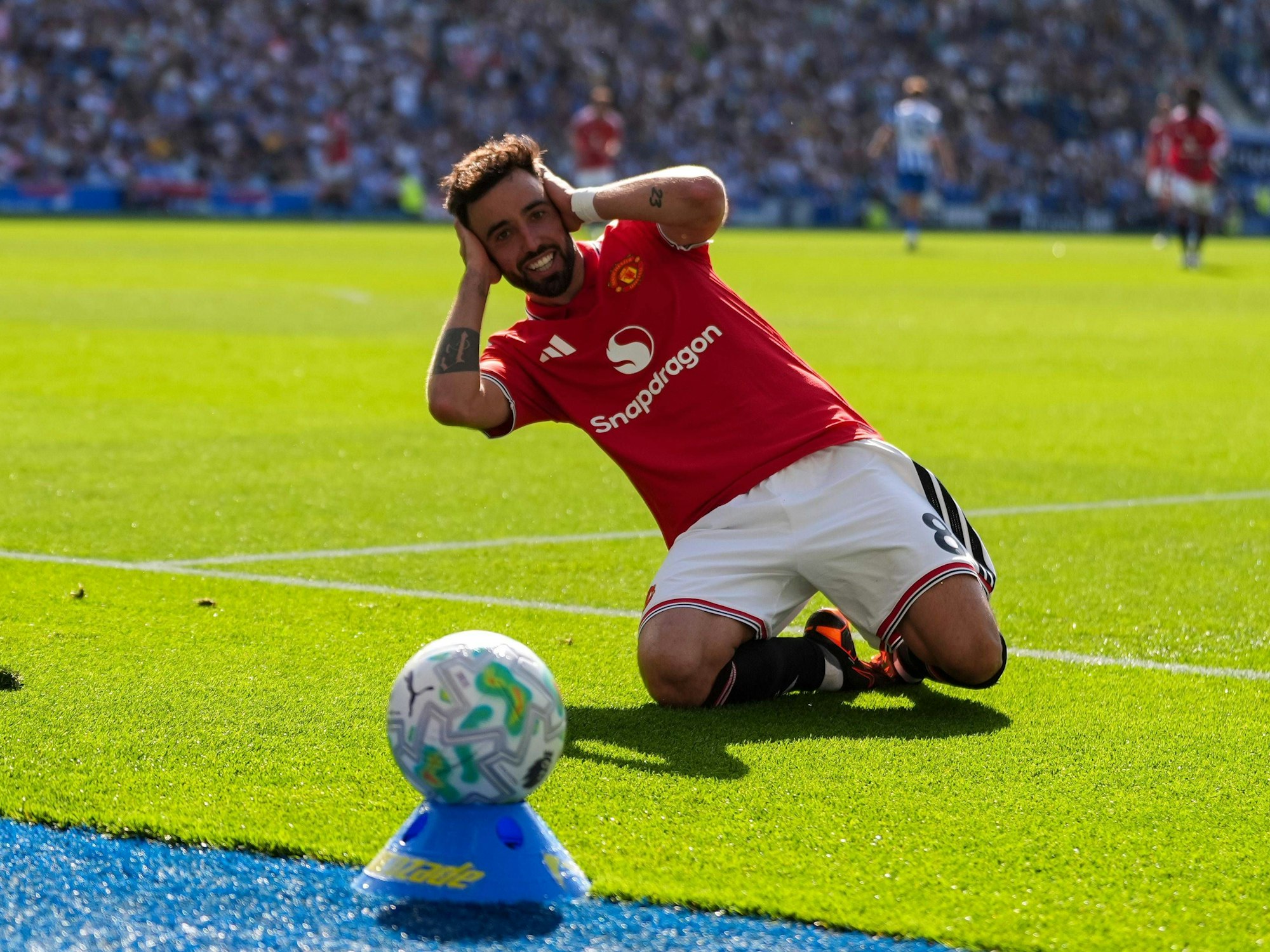 Bruno Fernandes kniet auf dem Rasen und fasst sich mit beiden Händen an den Kopf.