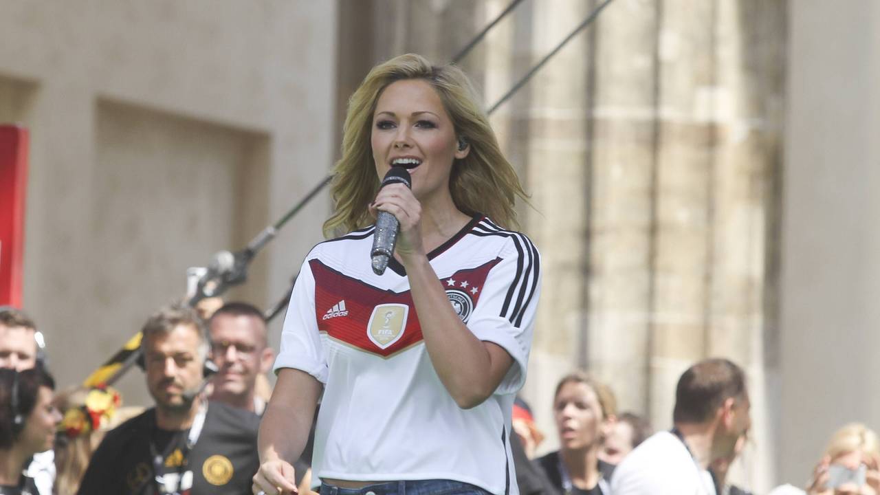Helene Fischer im Deutschlandtrikot und mit Mikrofon in der Hand.