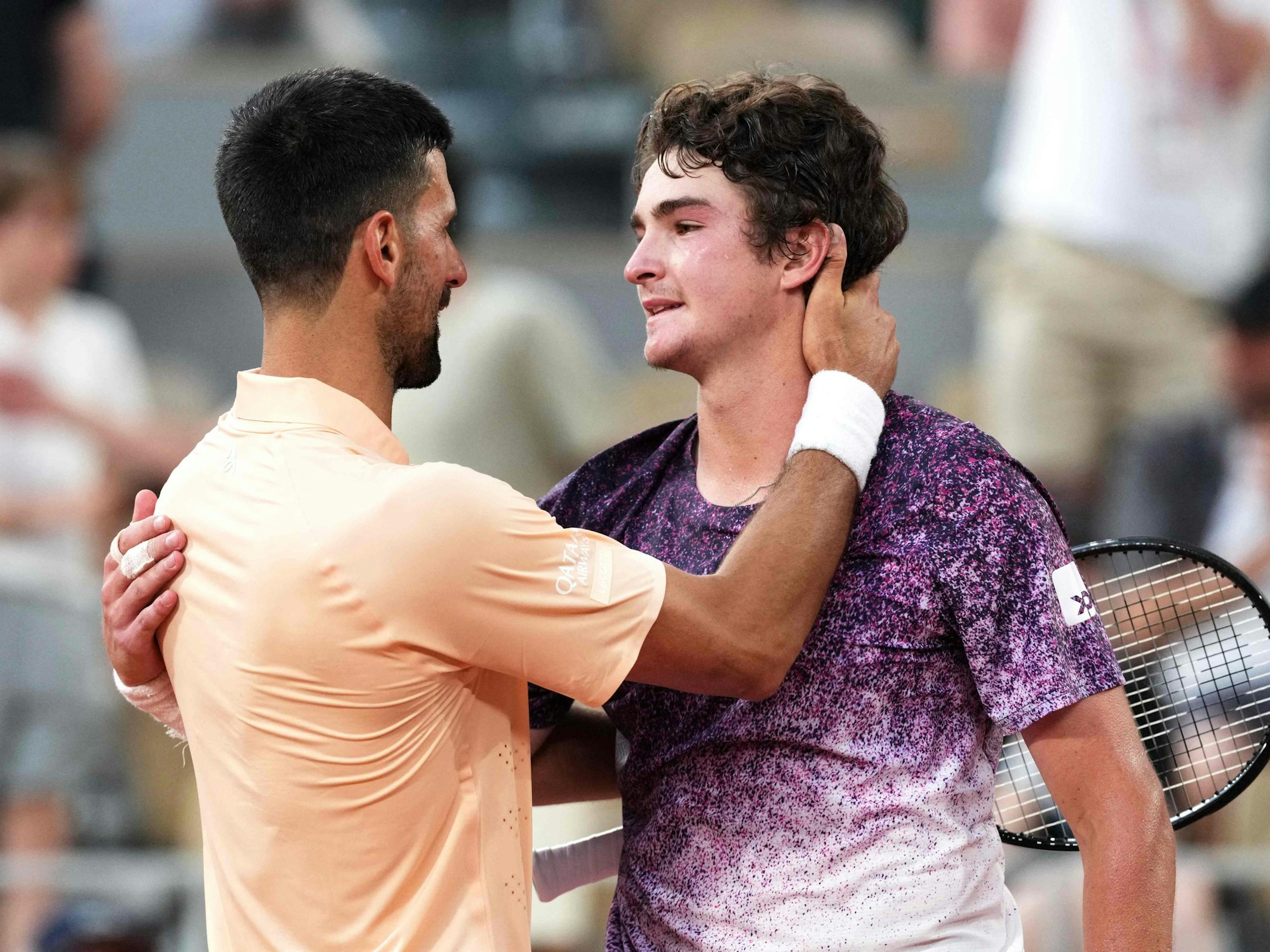 Novak Djokovic gratuliert dem Brasilianer Joao Fonseca nach dessen Sieg in fünf Sätzen bei den French Open.