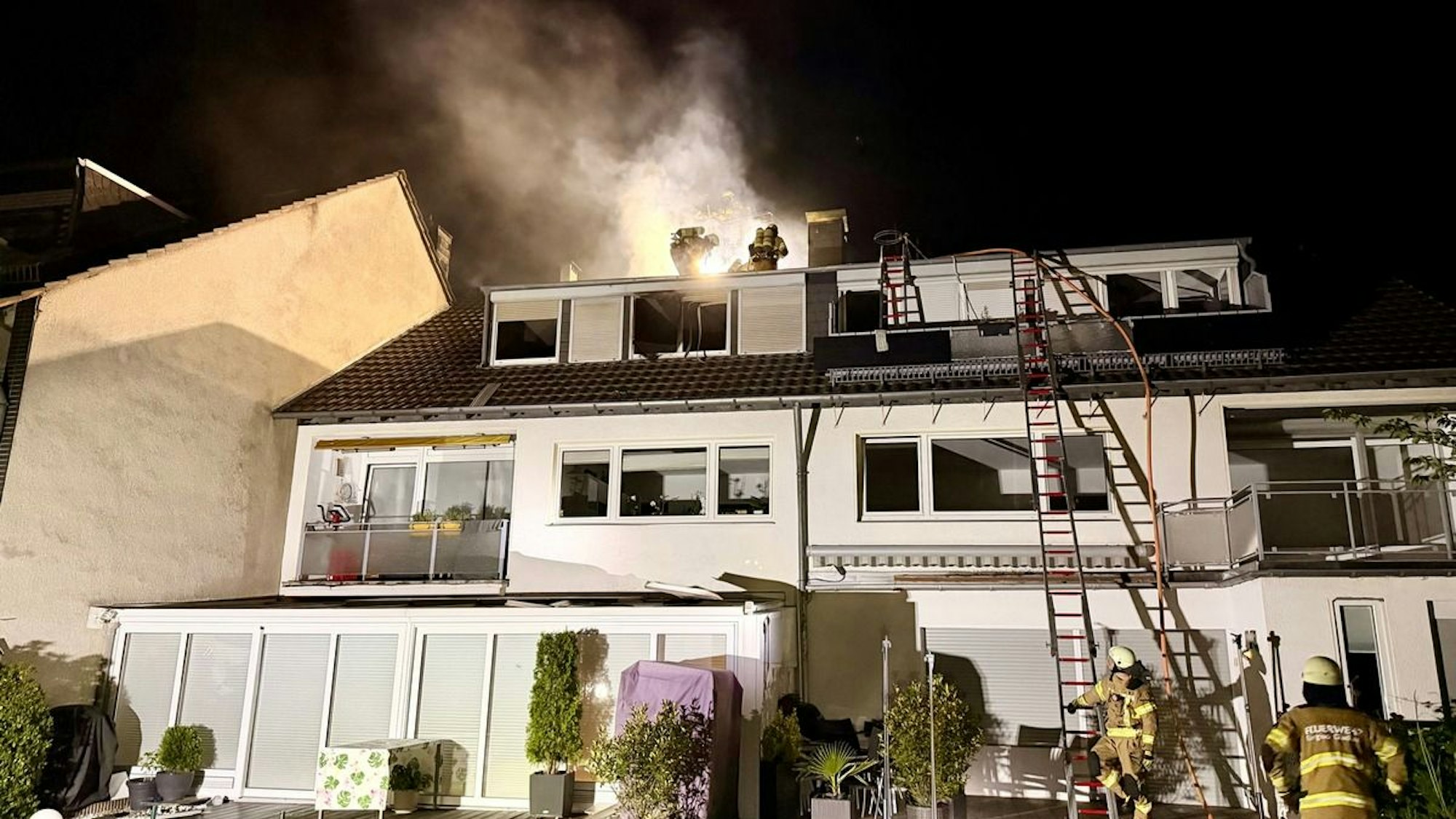 Der brennende Dachstuhl eines Hauses in Bergisch Gladbach.
