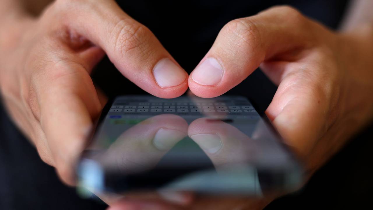 Ein Mann tippt auf einem Smartphone