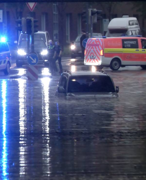 Ein Auto steht in Rheine in einer überfluteten Straße in einer Unterführung.