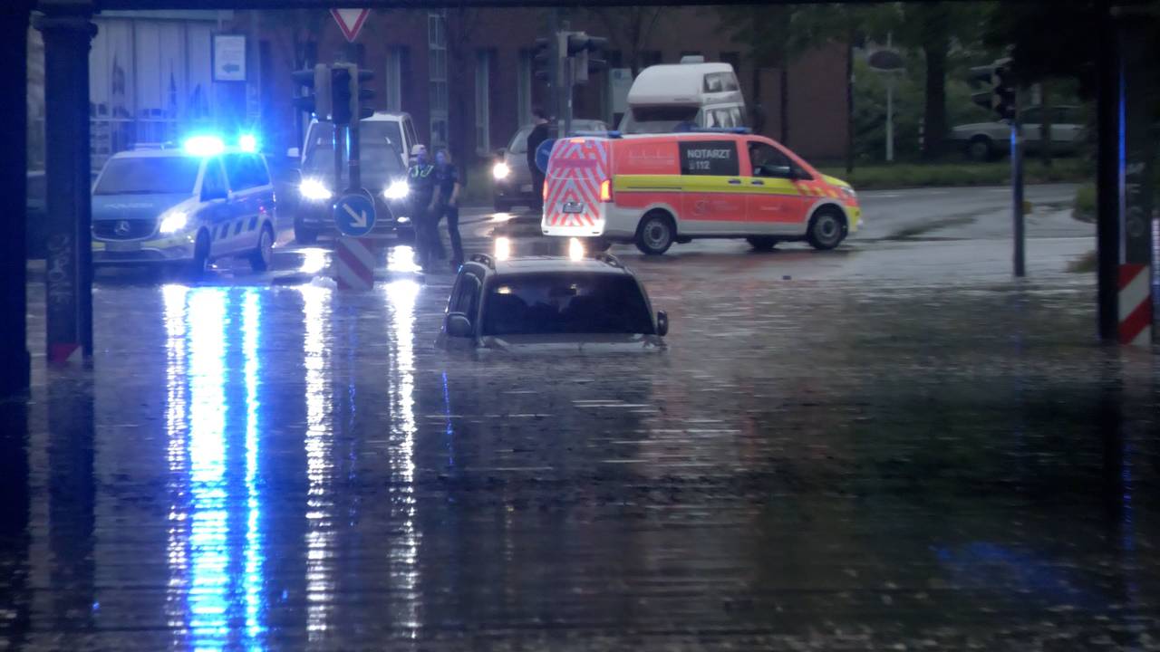 Ein Auto steht in Rheine in einer überfluteten Straße in einer Unterführung.