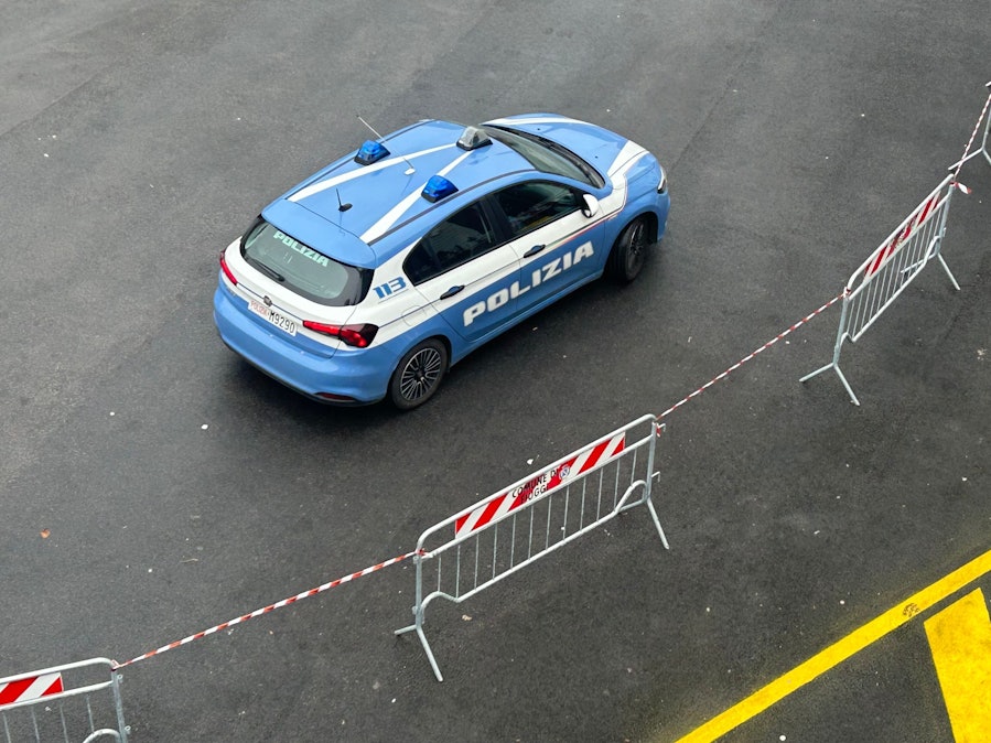 Italienisches Polizeiauto vor Absperrungen