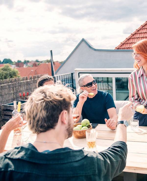 Eine Gruppe sitzt zusammen auf einer Dachterrasse