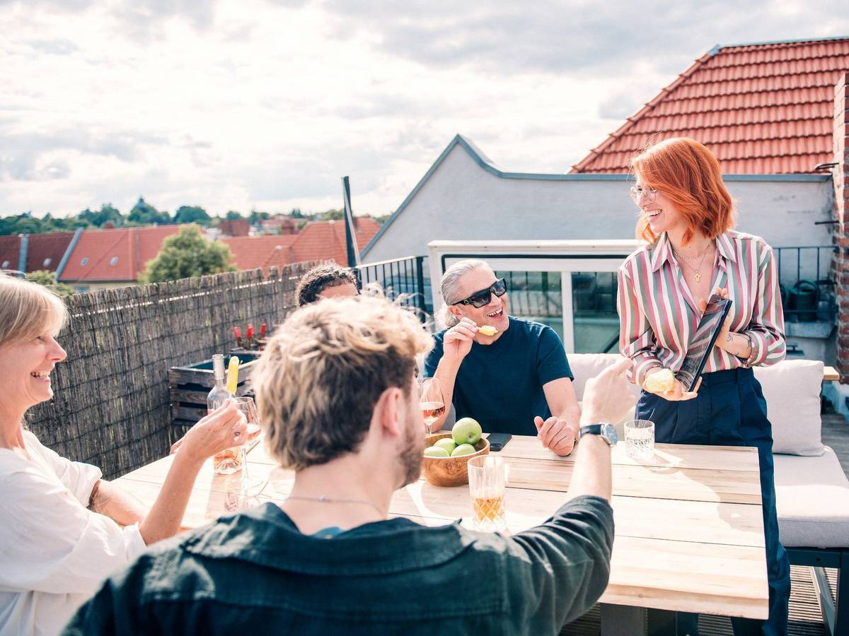 Eine Gruppe sitzt zusammen auf einer Dachterrasse