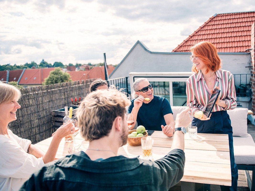 Eine Gruppe sitzt zusammen auf einer Dachterrasse