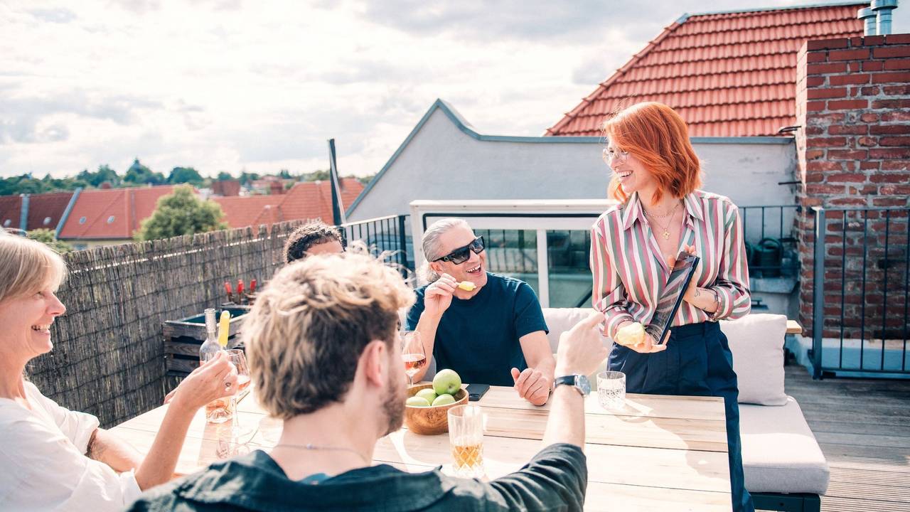 Eine Gruppe sitzt zusammen auf einer Dachterrasse
