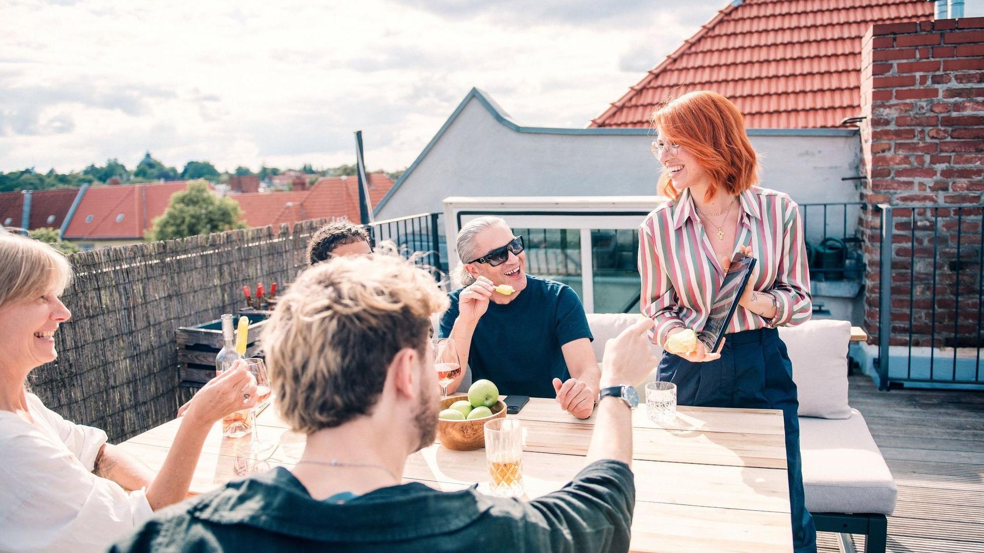 Eine Gruppe sitzt zusammen auf einer Dachterrasse