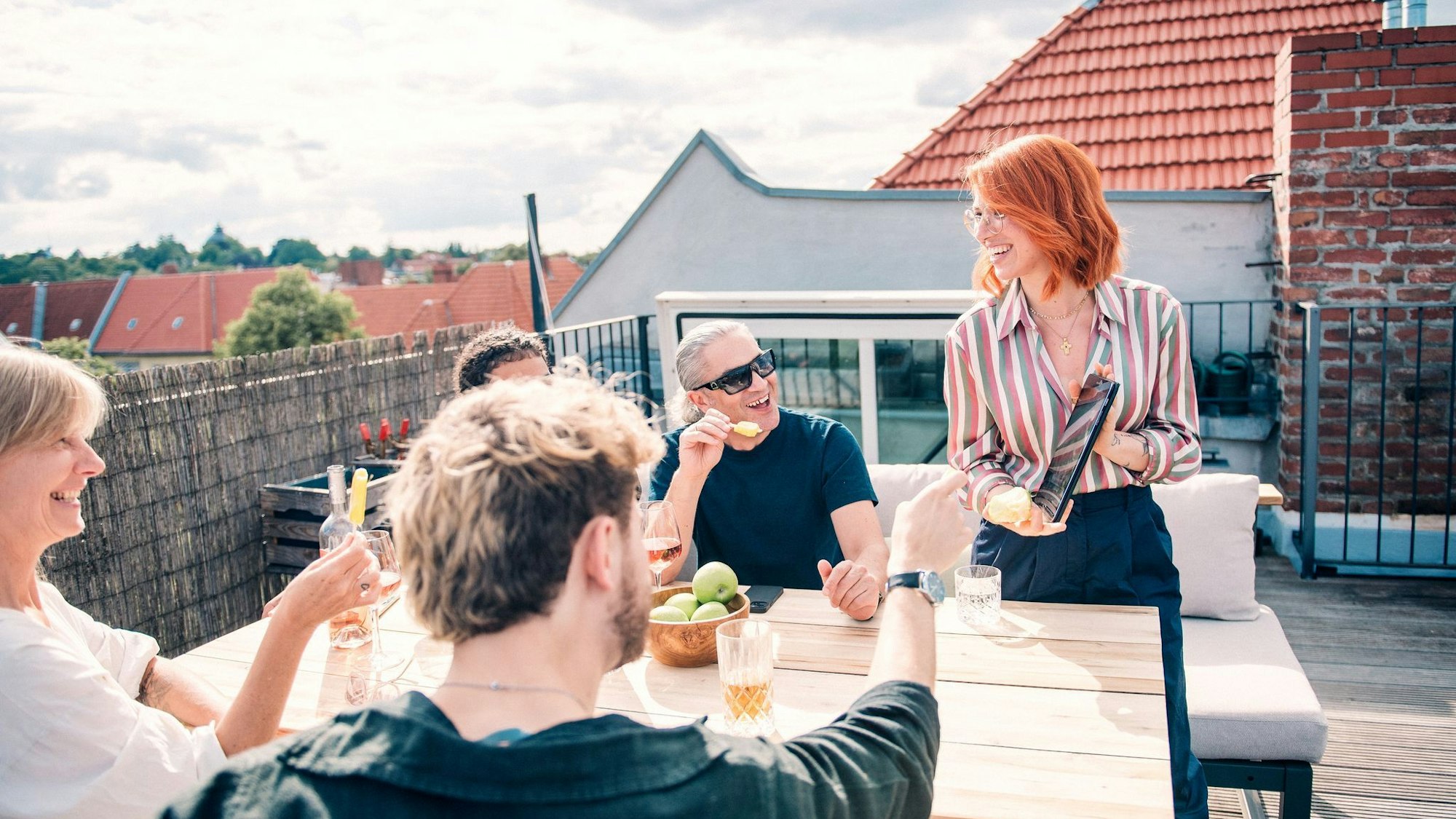Eine Gruppe sitzt zusammen auf einer Dachterrasse