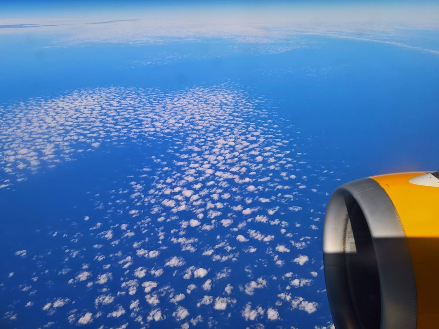 Flugzeug über Wolken und blauem Himmel