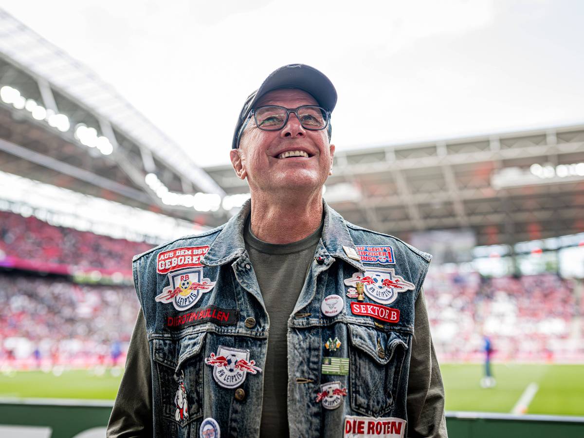 Ralf Rangnick mit Jeansweste mit Leipzig-Aufnähern vor der Fankurve.