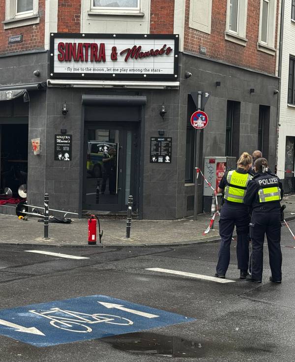 Blick auf die beschädigte Bar mit zerstörter Scheibe und Trümmern auf dem Boden.