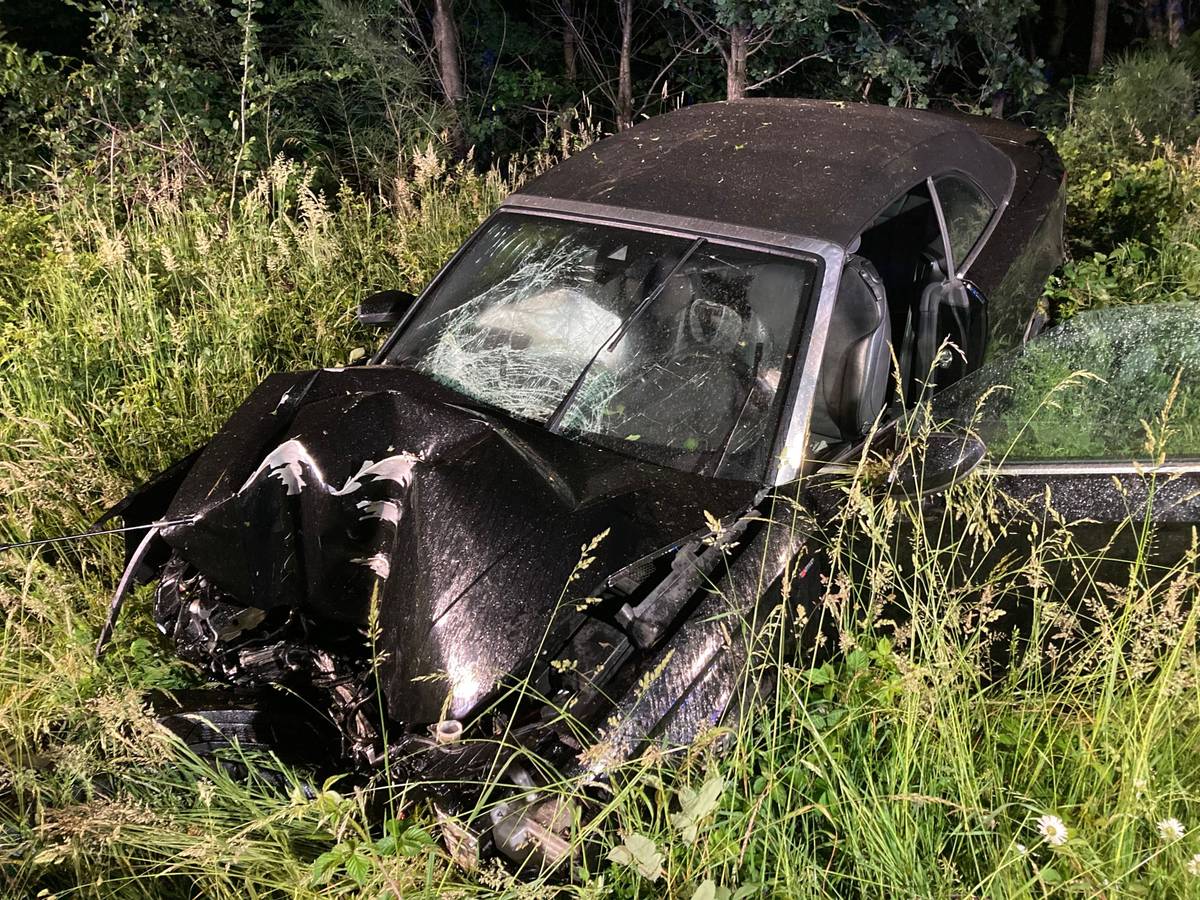 Ein Auto liegt völlig demoliert in einem Grünstreifen.