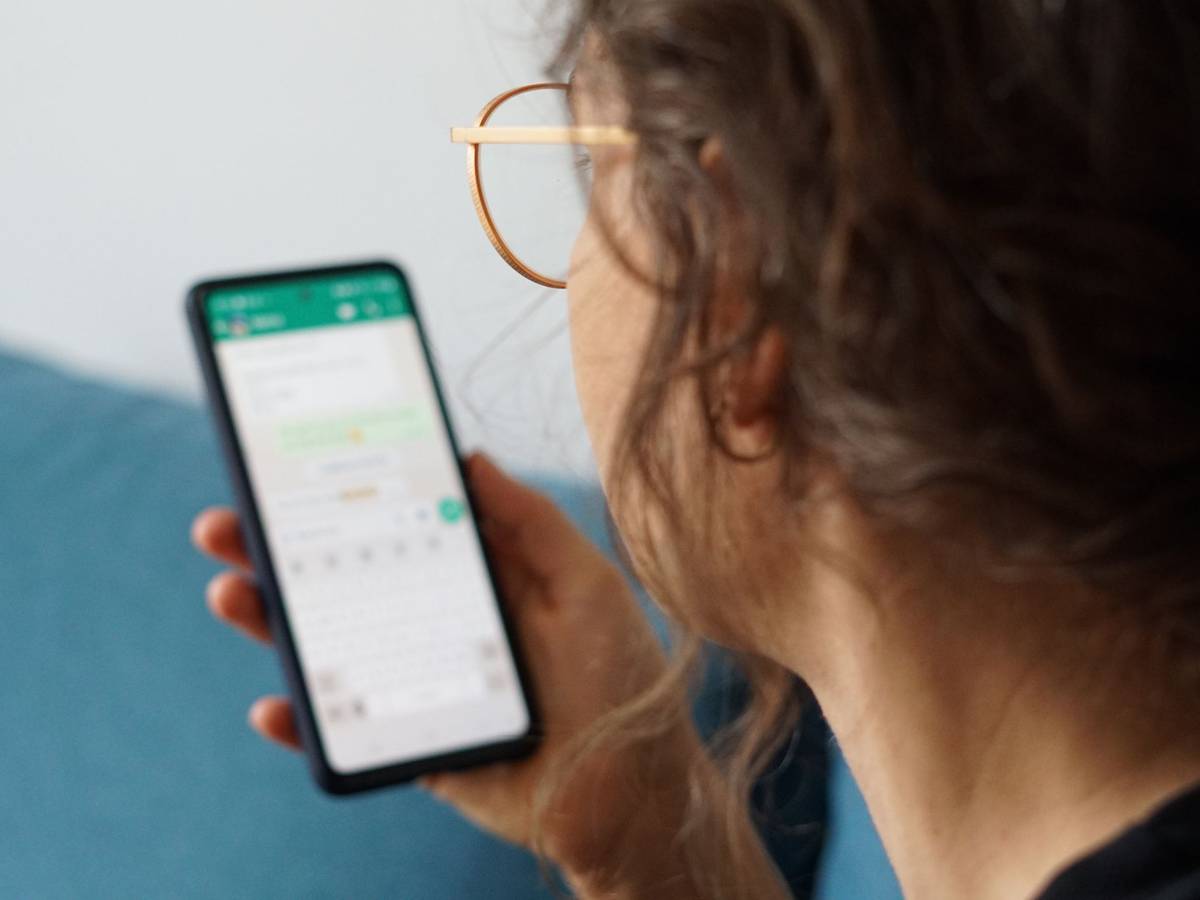 Eine junge Frau liest eine Nachricht auf einem Smartphone