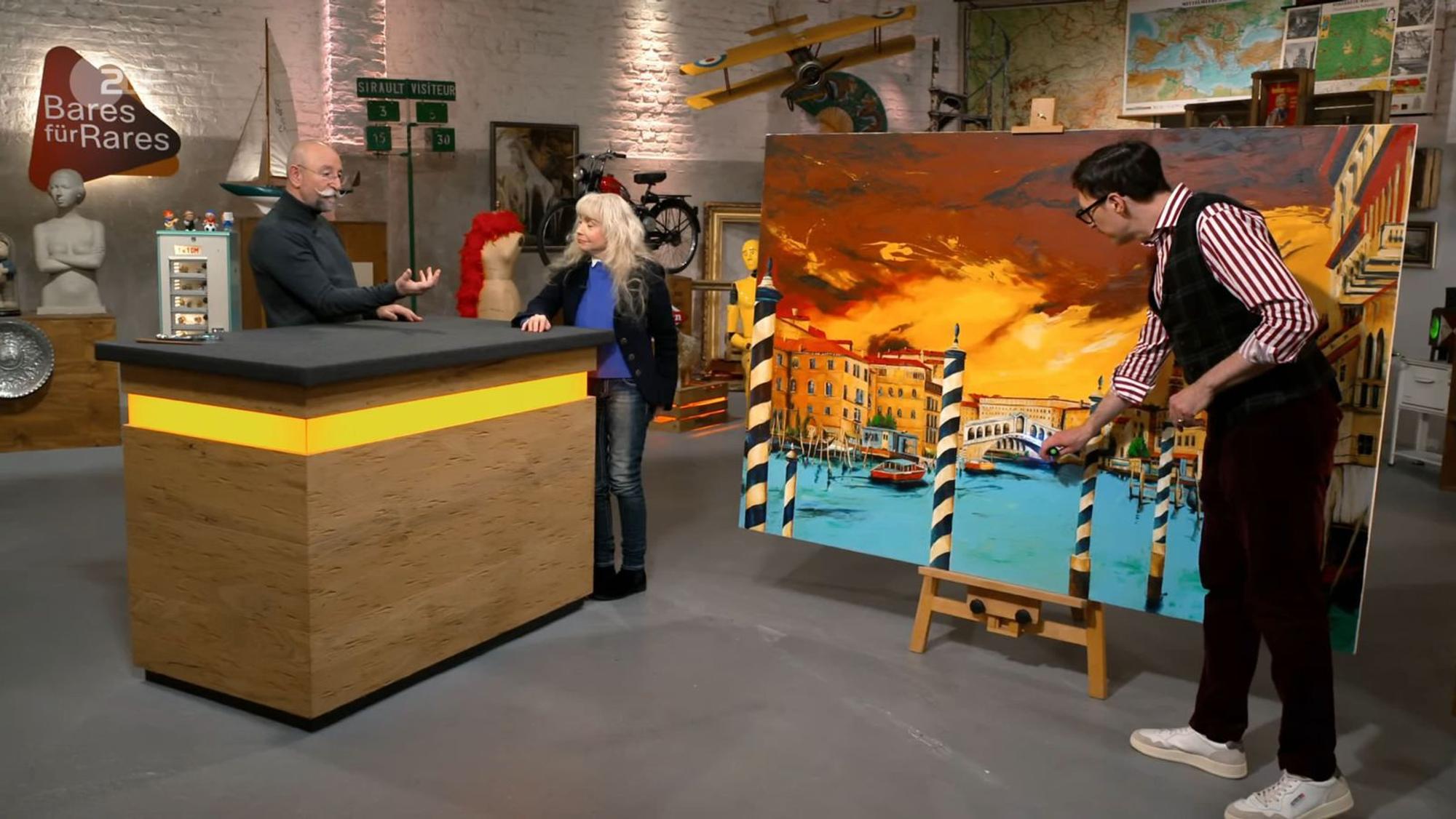 „Oh, wow! Was für ein ausgesprochen farbenfrohes Gemälde!“ So reagierte Horst Lichter (links) auf das „außergewöhnlich große Bild“, das ist seiner Trödelshow vorgestellt wurde. (Bild: ZDF)