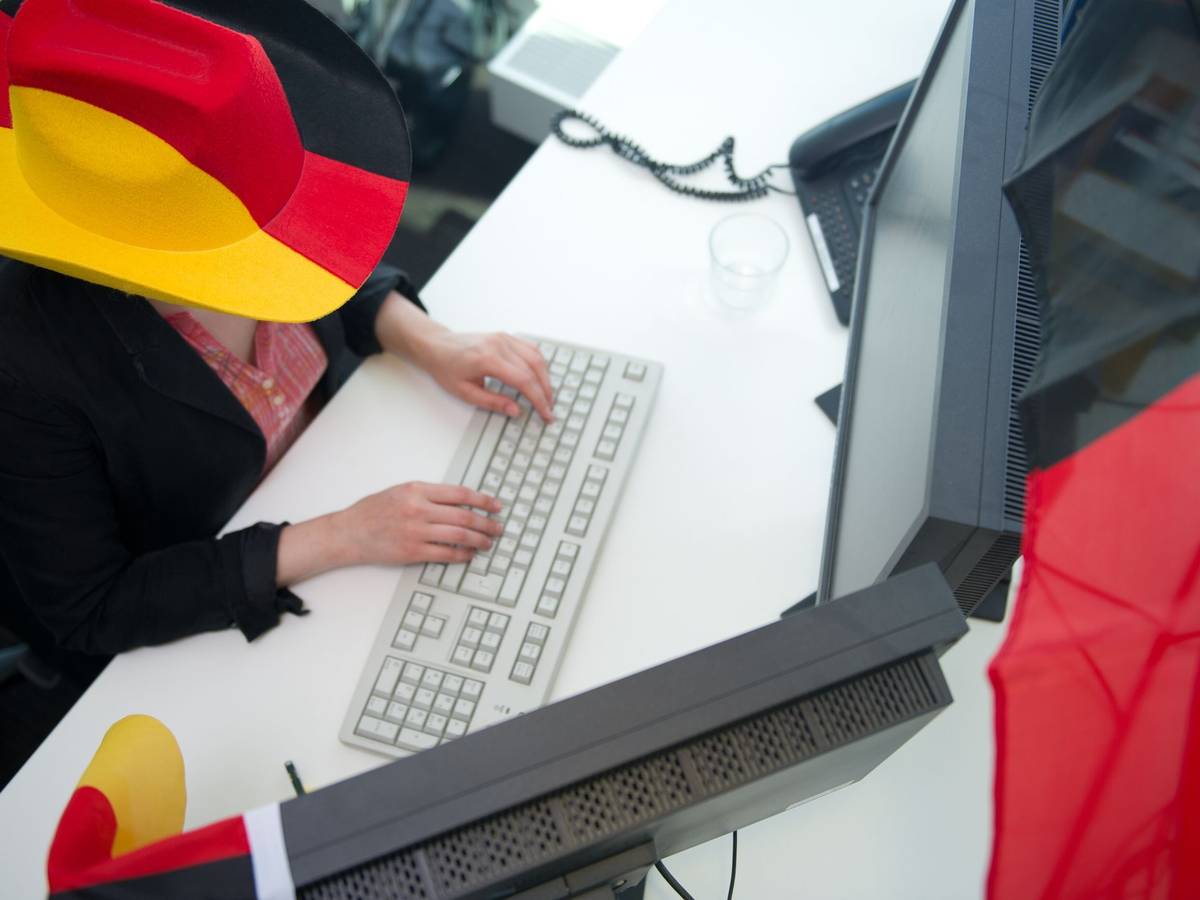 Eine Frau in Fankleidung am Arbeitsplatz