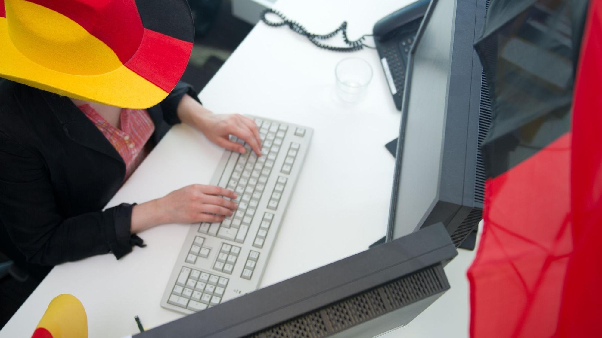 Eine Frau in Fankleidung am Arbeitsplatz
