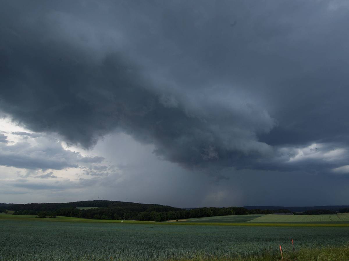 Bedrohliche Gewitterwolken über Feldern und Wald